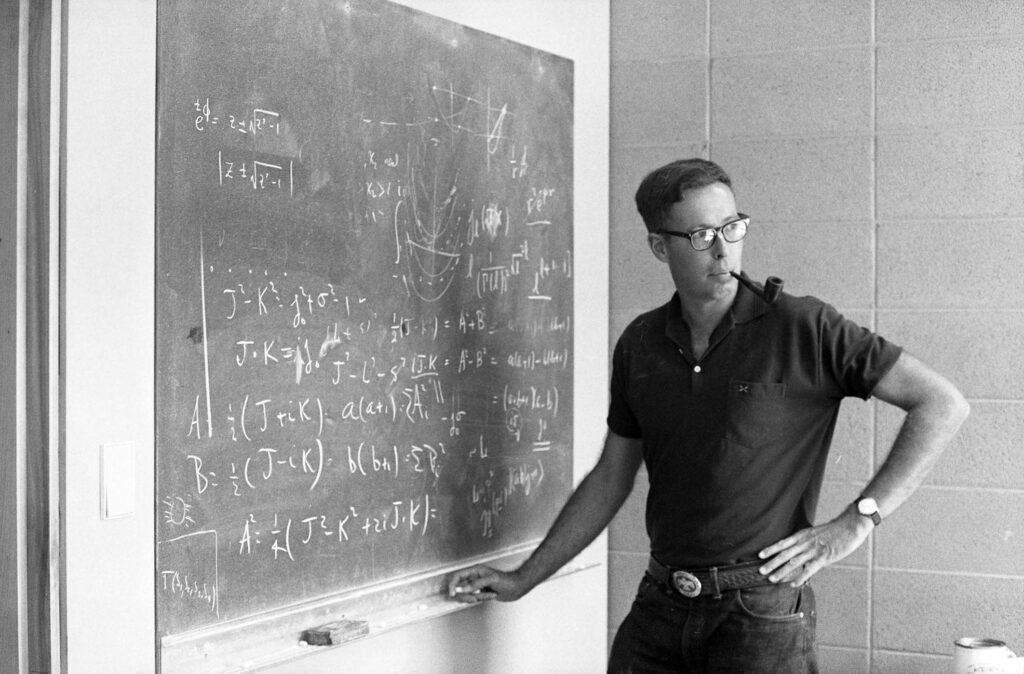 One b/w negative of Randy Durand at the Aspen Center for Physics, 1968. This image and a related article are in the Aspen Illustrated News on August 15, 1968 (pages 18-19), with a caption reading "Randy Durand, theorist from the University of Wisconsin, listens to a fellow physicist's criticisms of his equations. Blackboards are de rigueur in all Center offices."