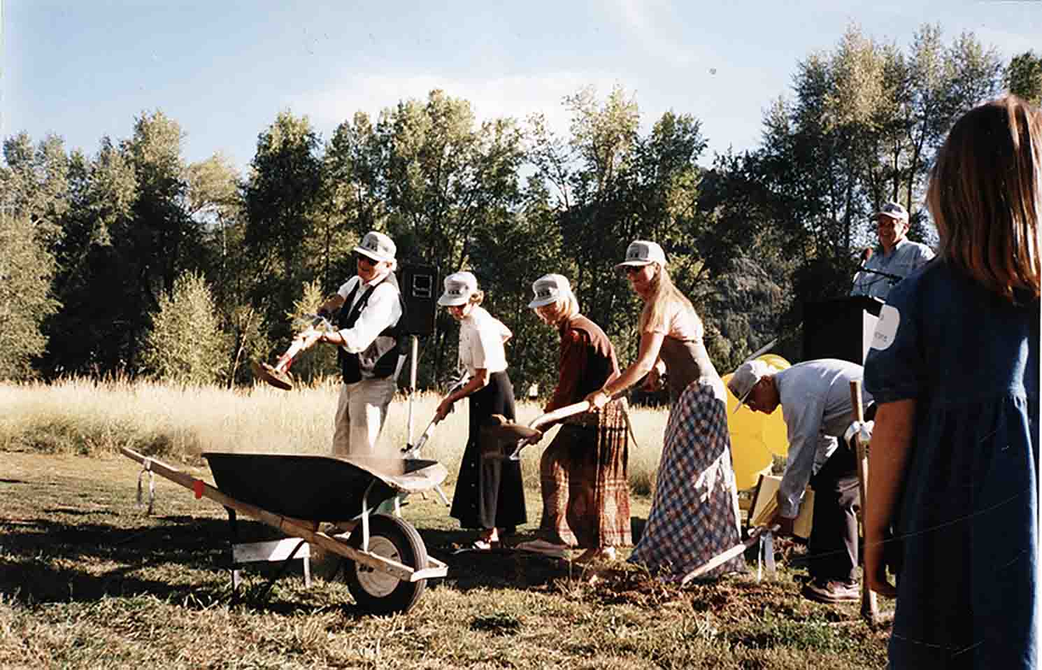 One color photograph of Leon Lederman, Judith Barnard, Judy Schramm, Debbie Flug, Murray Gell-Marm and Dave Schramm with shovels, digging at the ceremonial ground breaking for the new Aspen Center for Physics on September 1, 1995. Photo courtesy of Aspen Historical Society.